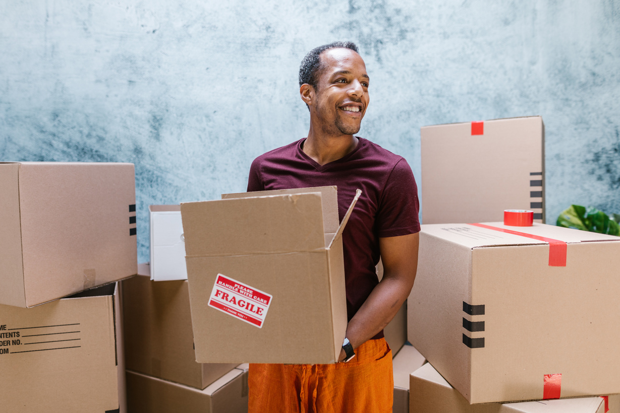 Man in Maroon Crew Neck T-shirt Holding Brown Box